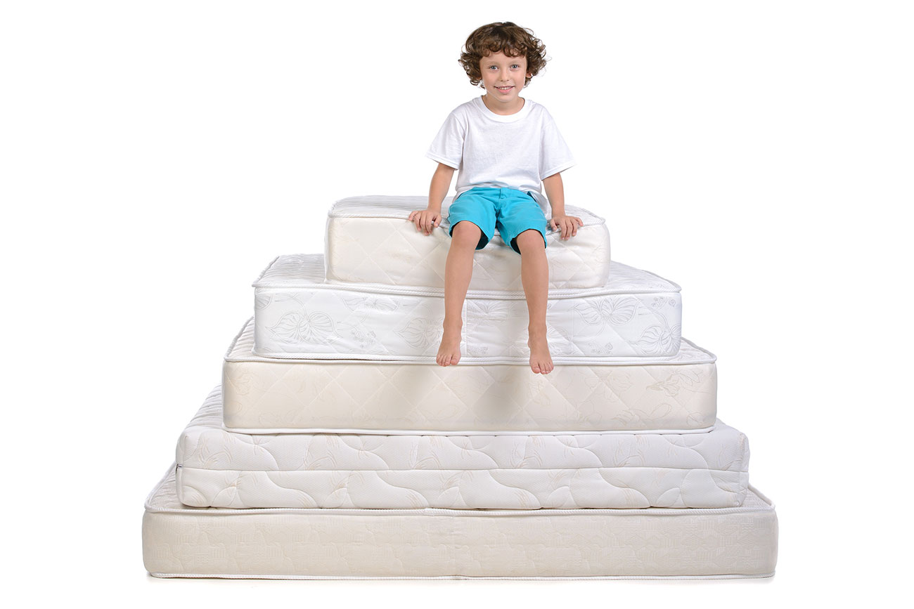 Kid-sitting-on-top-of-a-pile-of-mattresses